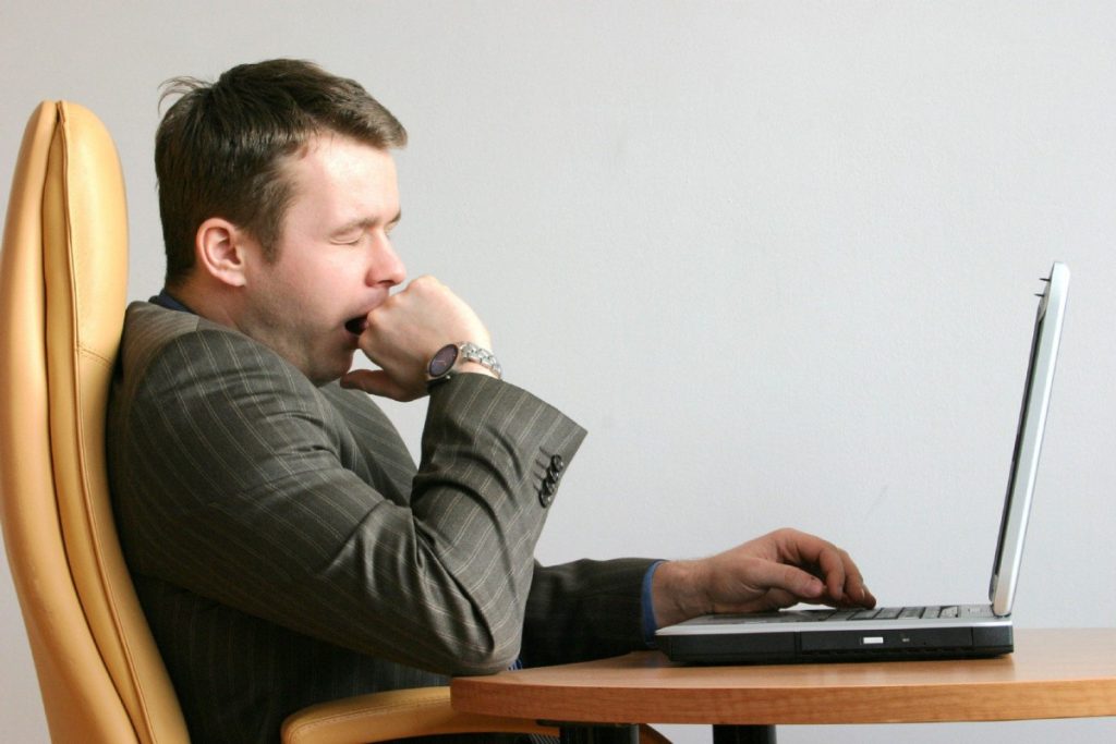 SHUTTERSTOCK IMAGE TORONTO STAR USE ONLY MAN YAWNING AT LAPTOP COMPUTER